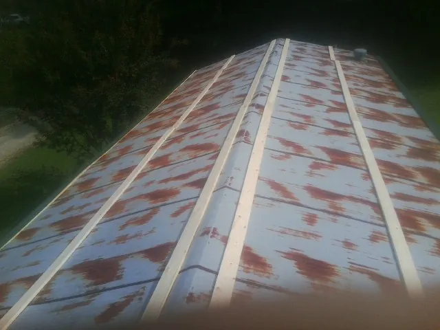 Rusted metal roof panels with new wood purlins before replacement — Storm Damage Roof Repair in Holder by Roofing Brothers