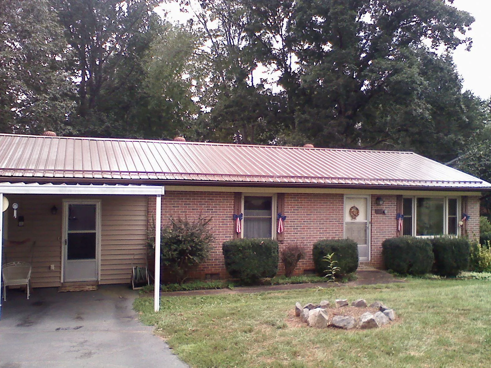 Bronze metal roof and carport on a brick ranch home — Roof Repair work by our crew in Holder